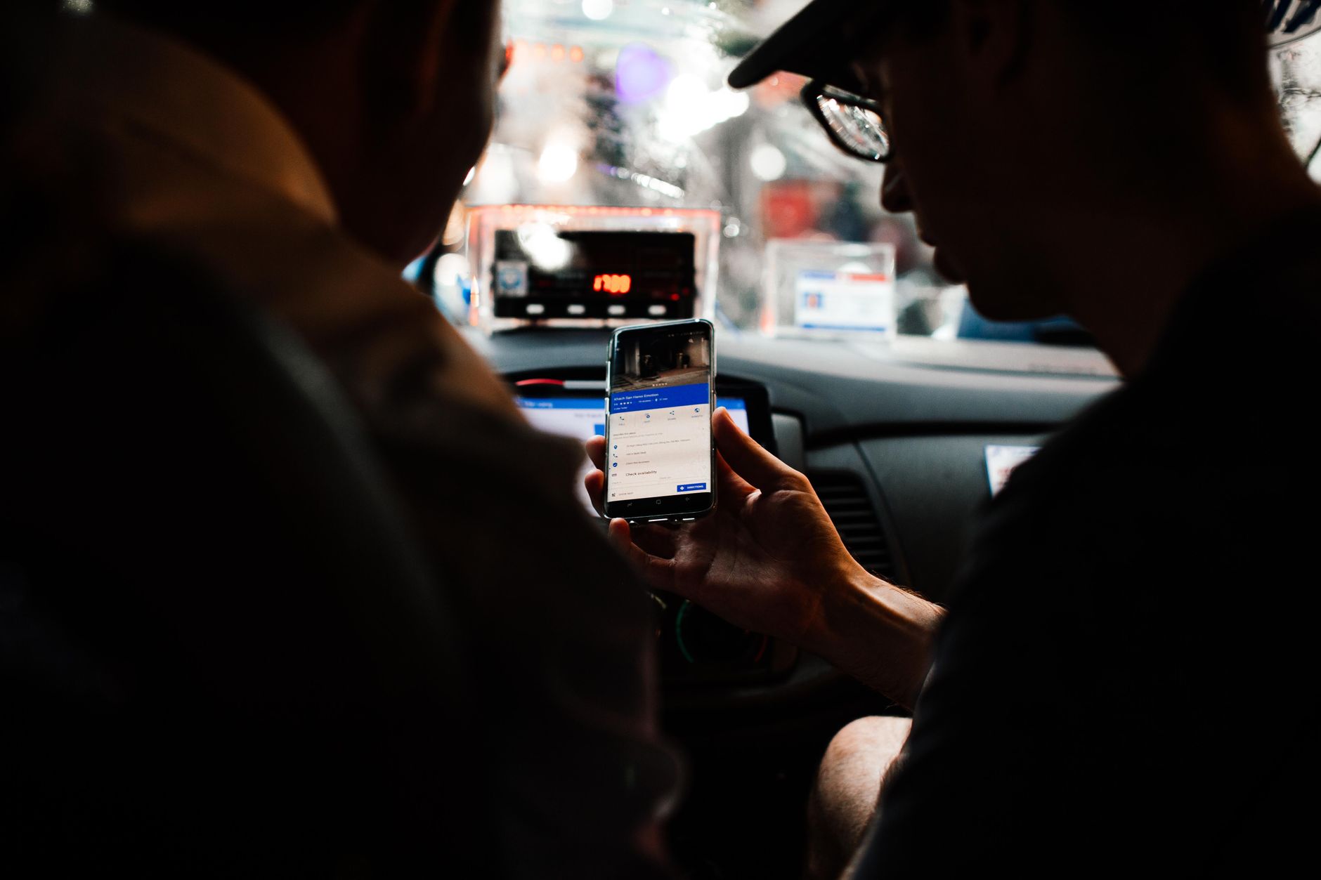 Passageiros a seguir o percurso na aplicação, dentro do carro, à noite